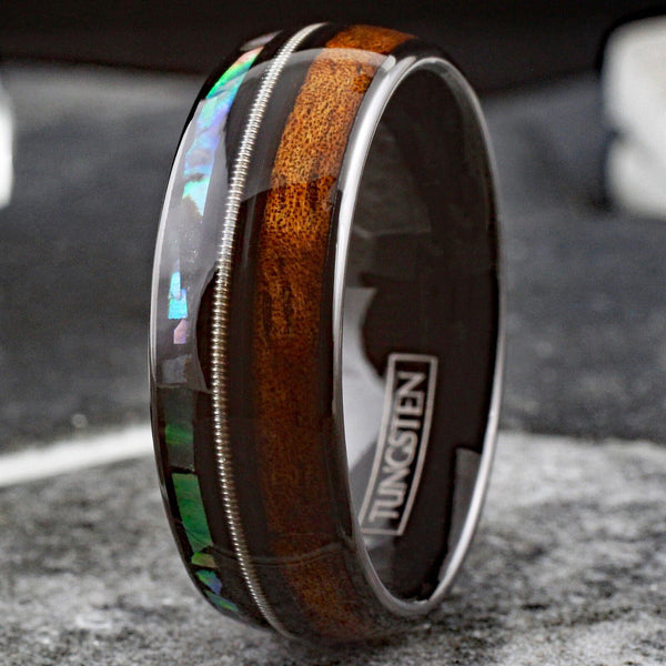 Cool Polished Black Tungsten Low Dome Ring with Silver Guitar String Between Iridescent Abalone And Whiskey Barrel Oak Wood Inlays.