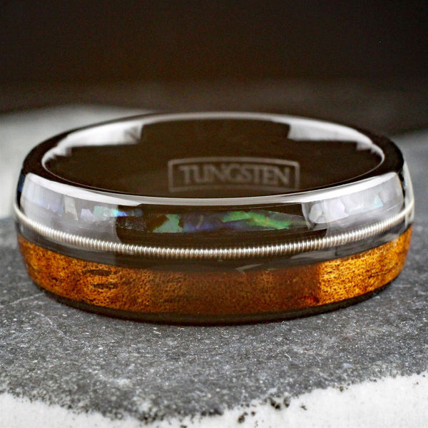 Cool Polished Black Tungsten Low Dome Ring with Silver Guitar String Between Iridescent Abalone And Whiskey Barrel Oak Wood Inlays.
