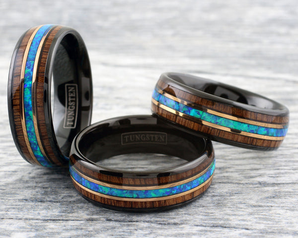 Gorgeous Polished Black Tungsten Low Dome Band Ring with Iridescent Man-Made Crushed Hawaii Blue Opal Inlay Between Two Rose Bands Surrounded By Koa Wood Inlays.