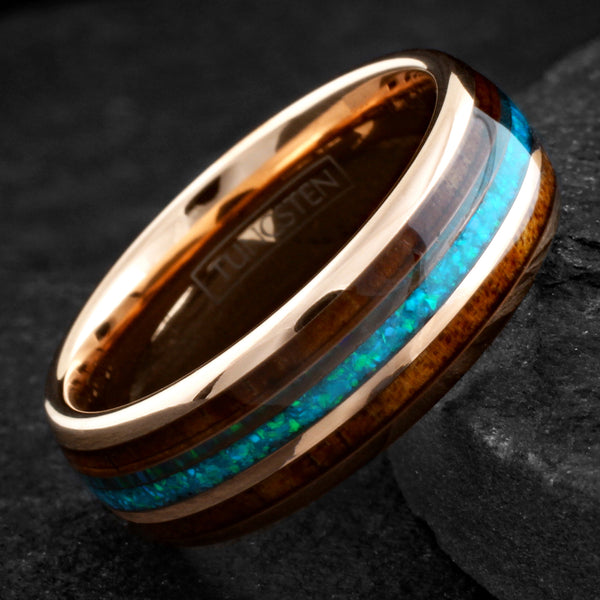 Dazzling Polished Rose Gold Tungsten Low Dome Band Ring with Iridescent Man-Made Crushed Hawaii Blue Opal Inlay Between Two Koa Wood Inlays.