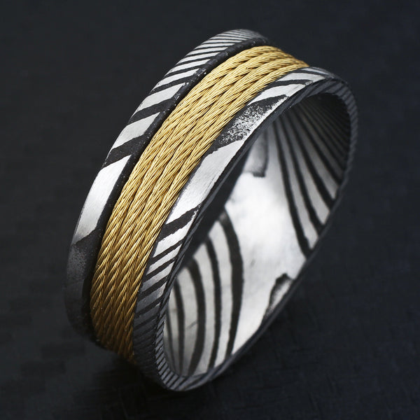 Antiqued black & silver Damascus Steel band ring w/ 4 gold stainless steel cable inlays | Black tilted photo