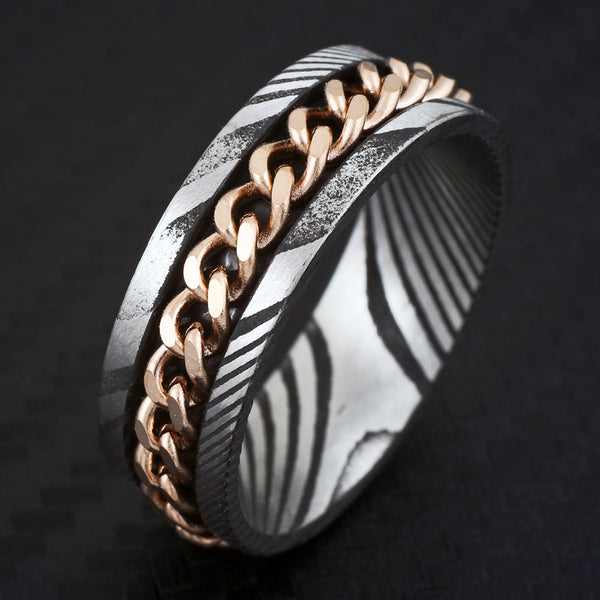Antiqued black & silver Damascus Steel band ring w/ rose gold Cuban chain inlay | Black tilted photo