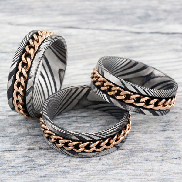 Antiqued black & silver Damascus Steel band ring w/ rose gold Cuban chain inlay | Group photo