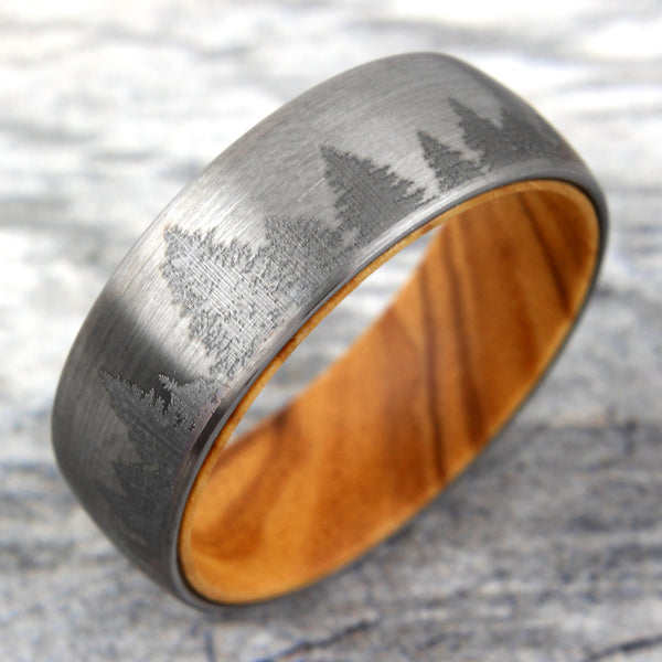 Brushed Finish tungsten carbide band ring w/ etched forest scene & olive wood inner band | Wholesale wedding bands | Marble tilted photo
