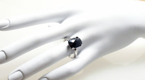 Ring with 10x14mm rectangular black / obsidian colored CZ solitaire. Wholesale sterling silver rings. Hand photo.